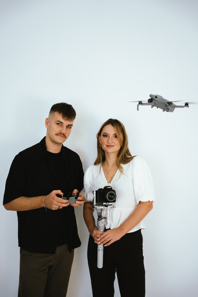 Natalia i Krzysztof z aparatem, gimbalem i dronem na białym tle